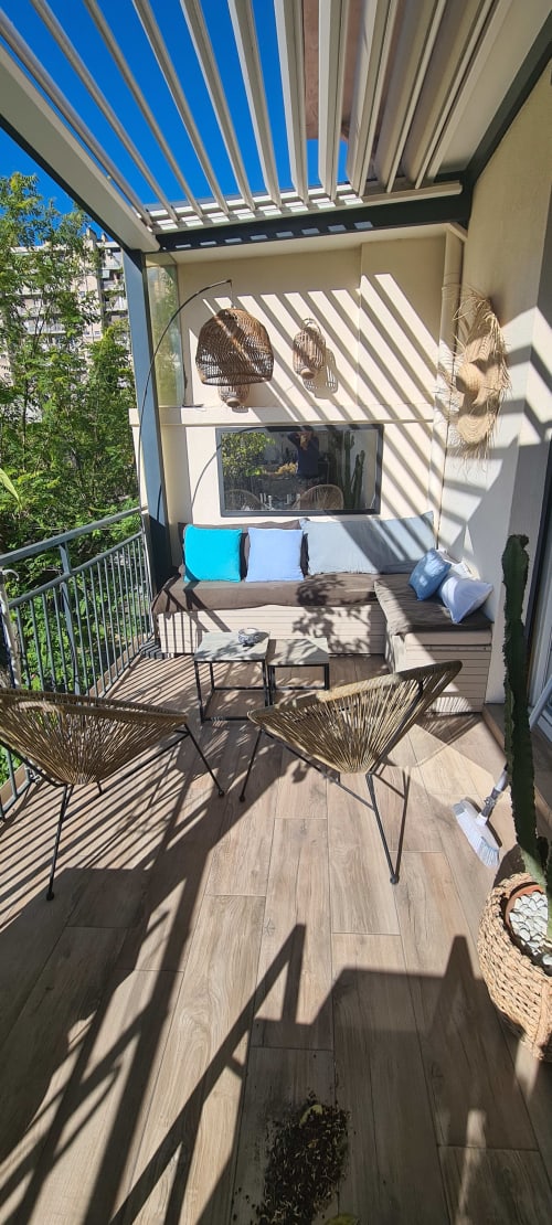Balcon ensoleillé du Cocon de Chris Marseille avec salon de détente, chaises tressées et pergola ajustable