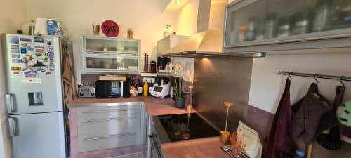 Cuisine moderne de l'appartement Le Cocon de Chris à Marseille, équipée d'électroménagers en acier inoxydable et de plans de travail foncés