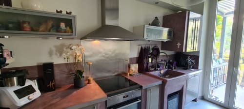 Cuisine moderne à l'appartement Le Cocon de Chris à Marseille avec appareils en acier inoxydable et accents bordeaux