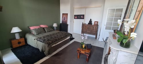 Chambre moderne au Cocon de Chris Marseille : murs verts, mobilier en bois, orchidées blanches sur la commode, décoration élégante