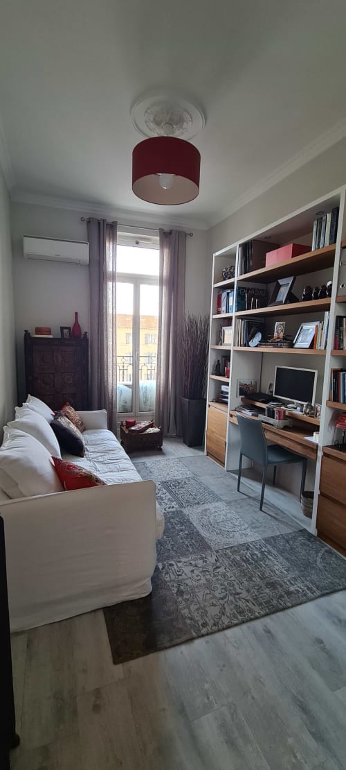 Chambre moderne au Cocon de Chris Marseille avec lit, étagères intégrées, bureau et lampadaire bordeaux