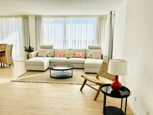 Bright ocean view living room at Sunset hotel in Arguineguín with cream sectional sofa, colorful pillows, and modern