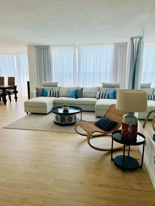 Modern living room with cream sectional sofa, blue accents, ocean views at Sunset hotel in Arguineguín