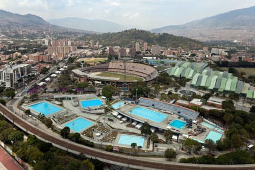 Vista aérea del complejo deportivo de Cali con estadio olímpico, centros acuáticos y montañas circundantes
