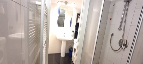 Modernes Badezimmer in einer Mailänder Wohnung mit Säulenwaschtisch, Dusche, Handtuchhalter und Waschmaschine