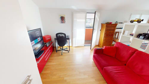 Modernes Wohnzimmer in Milano mit rotem Sofa, TV, Holzböden und Balkonzugang im Come a Casa Tua
