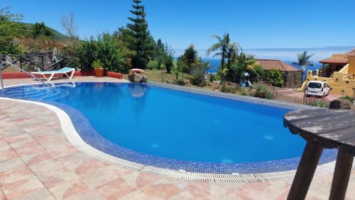 Piscina de formas curvas con agua azul en el hotel Casonas de Marengo en Icod de los Vinos, Tenerife, con vistas al océano