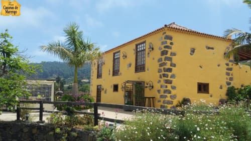 Cabaña amarilla con detalles de piedra volcánica, jardín tropical y vistas a las montañas en Casonas de Marengo, Icod de los Vinos