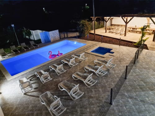 Night view, large wooden terrace of 100 m² with large heated swimming pool at villa casa claudina for rent in Loulé in the Algarve.