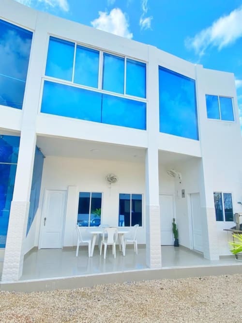 Moderno edificio hotelero blanco con ventanas azules en Olamar Living, Santiago de Tolú, Colombia