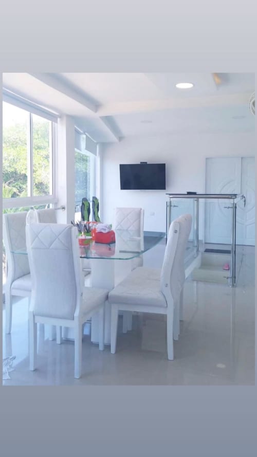 Suite moderna Olamar en Santiago de Tolú con comedor, sillas blancas, TV y ducha de cristal