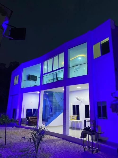 Hotel Olamar Living en Santiago de Tolú iluminado con vibrante iluminación azul durante la noche