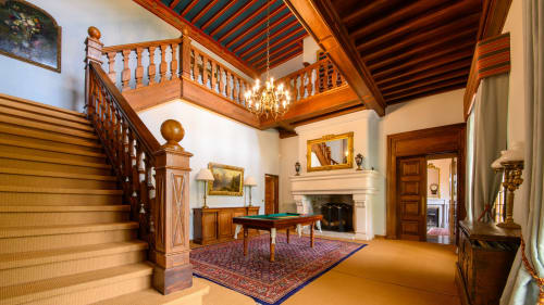 Grand salon de jeu de manoir avec escalier en bois, cheminée et billard à Mirepoix