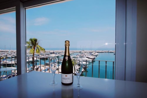 Champagne bottle and glasses on balcony overlooking Puerto Banús marina, Marbella sea view penthouse