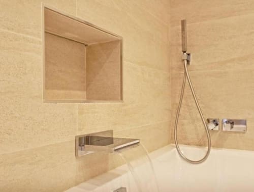 Modern bathroom with walk-in shower, wall-mounted faucet, and built-in niche in Marbella penthouse
