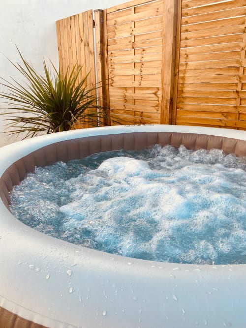 Bain à remous frémissant dans le jardin de la villa à Tiny Harmony, Venelles, avec clôture en bois et plantes tropicales