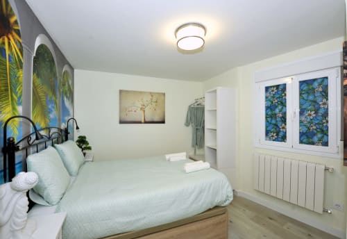 Dormitorio luminoso en el hotel Megaleon de Segovia con cama queen, arte botánico y comodidades modernas