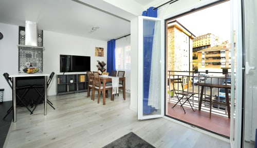 Moderno interior del apartamento del hotel Megaleon en Segovia con chimenea, TV, comedor y balcón con vistas a la ciudad