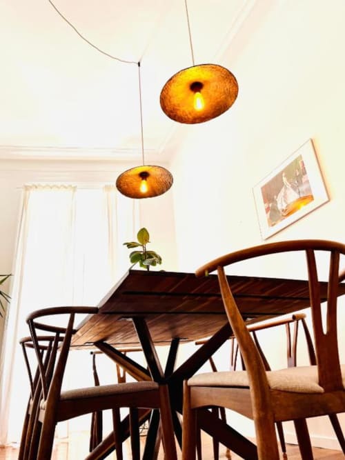 Modern dining area with wooden chairs, amber pendant lights, and garden view at Royal Prince Garden Apartments in Lisboa