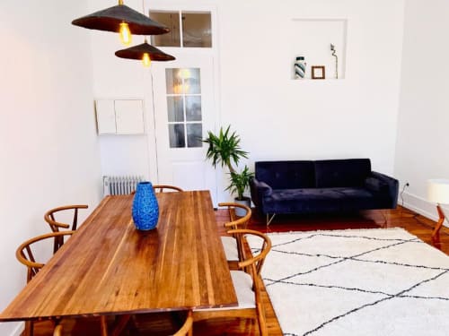 Modern living room with wooden dining table, blue sofa, and pendant lights at Royal Prince Garden Apartments, Lisboa