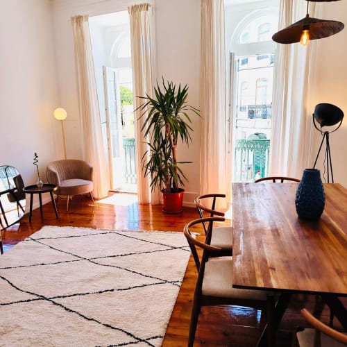 Interior moderno de apartamento no Royal Prince Garden Apartments Lisboa com pisos de madeira, mesa de jantar e cadeiras de meados do século