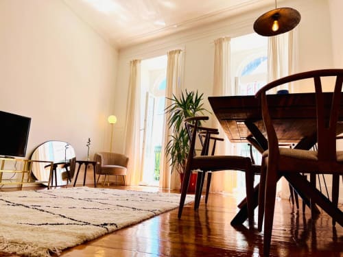 Modern apartment interior at Royal Prince Garden Apartments in Lisbon with dining table, dark wood chairs, and bright windows