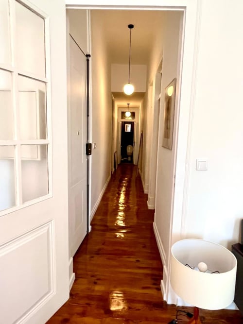 Long hallway with wooden floors, white doors, pendant lights at Royal Prince Garden Apartments, Lisboa