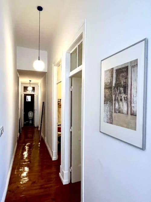 Modern hallway at Royal Prince Garden Apartments, Lisboa, with pendant lighting, framed artwork, and polished dark wood