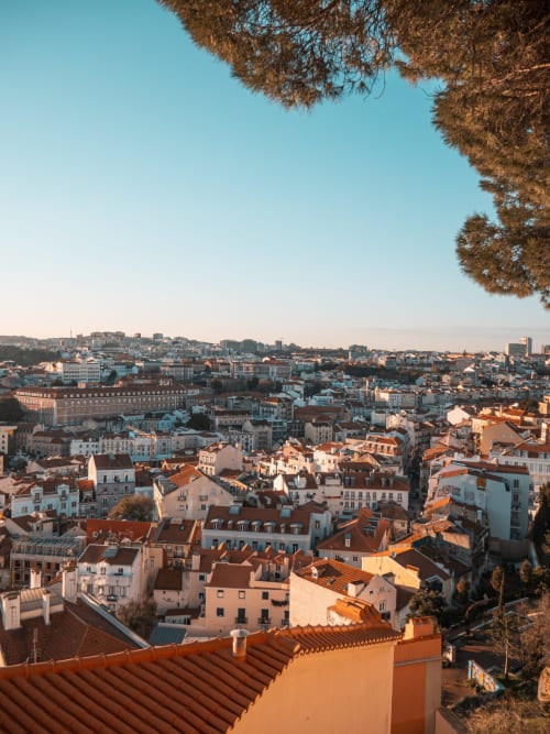 Vista da Lisboa ao pôr do sol com telhados de terracota e céu azul, Apartamentos Royal Prince Garden