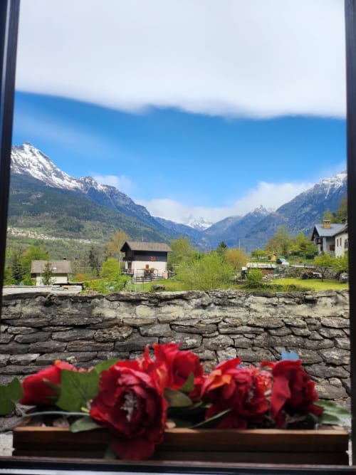 Rose rosse sul davanzale con vista sulla valle alpina, Locanda del Sasso Rooms, Crodo Italia