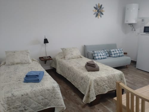 Quarto claro em Casa do Pão com duas camas, sofá e vista para o jardim em Campinho, Portugal