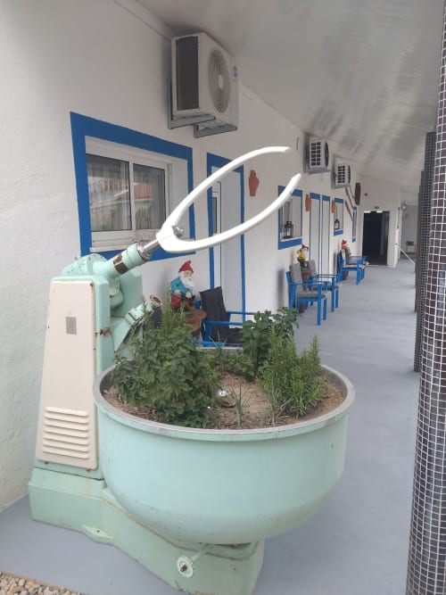 Pátio aconchegante com cobertura na Casa do Pão, floreiras decorativas, detalhes azuis e área de estar externa em Campinho