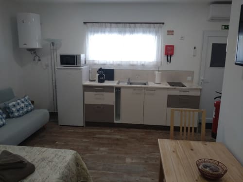 Cozinha e sala de estar modernas da Casa do Pão com fogão, micro-ondas, geladeira e mesa de jantar