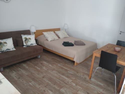 Modern bedroom at Casa do Pão with bed, sofa, wooden desk, and beige bedding in Campinho