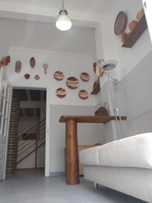 Bright living room at Casa do Pão with white walls, wooden table, cream sofa, and decorative ceramic plates arranged on