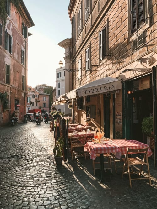 Affascinante via romana con pizzeria, tovaglie a scacchi rossi e storici edifici in terracotta