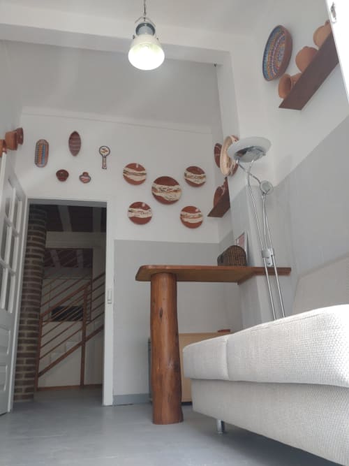 Interiormente moderno do apartamento em Casa do Pão com paredes brancas, móveis de madeira, pratos decorativos, luz pendente e