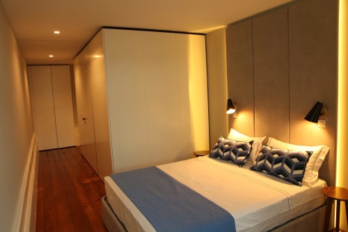 Quarto moderno no New Oporto Apartments Porto com cama de casal, iluminação aconchegante e piso de madeira