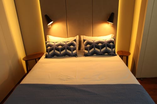 Superior Apartment bedroom at New Oporto Apartments in Porto with queen bed, geometric pillows, and warm ambient lighting