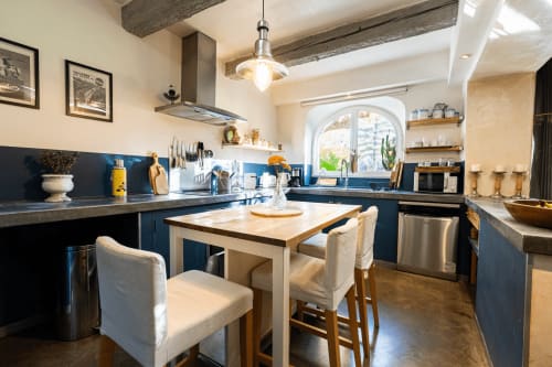 Cuisine moderne avec meubles bleus, table en bois et chaises blanches au Mas F B&B à Saint-Rémy-de-Provence