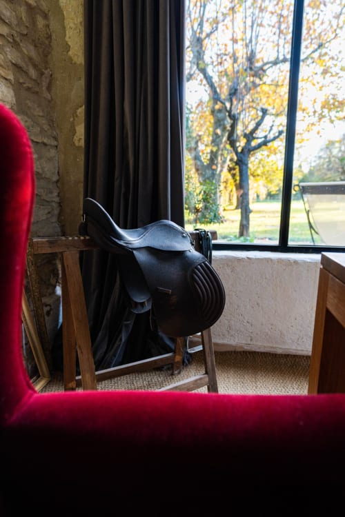 Selle en cuir noir exposée dans la chambre rustique du gîte Le Mas F, à Saint-Rémy-de-Provence