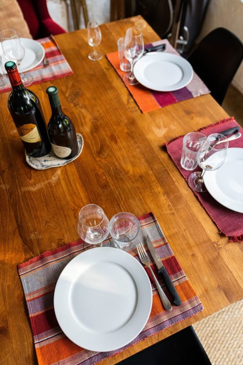 Table élégante au Mas F à Saint-Rémy-de-Provence, dressée avec couverts, verres à vin et bouteilles prêts pour