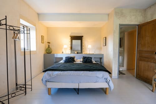 Chambre lumineuse au Mas F à Saint-Rémy-de-Provence avec lit, miroir et fenêtres sur le jardin