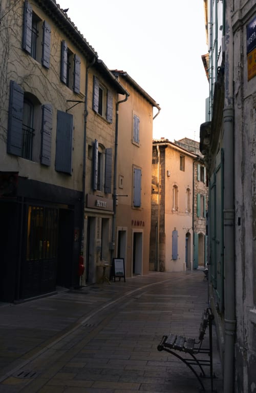 Charming cobblestone street in Saint Remy de Provence with historic stone buildings and blue shutters