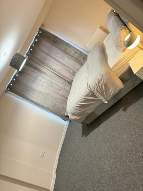 Bedroom at Cila Property Manchester apartment with bed, window blinds, wooden flooring, and modern furnishings