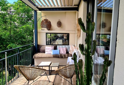 Coin salon cosy sur la terrasse du Cocon de Chris à Marseille avec chaises tressées, cactus en pots et lounge couvert.
