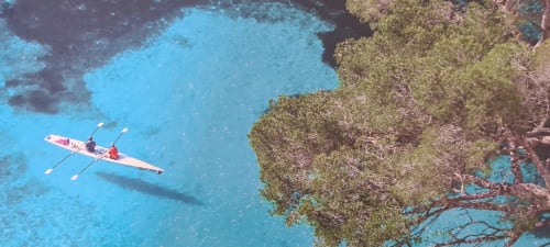 Vue aérienne d'un kayakiste sur les eaux turquoise méditerranéennes près du Cocon de Chris, Marseille