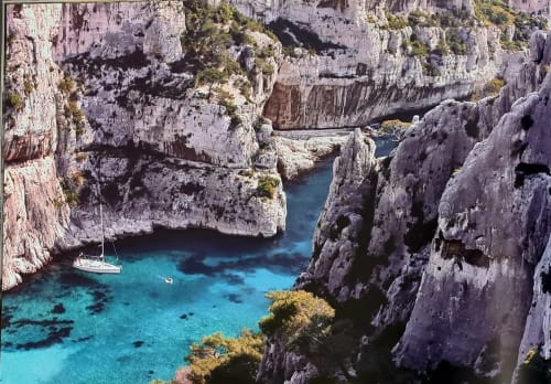 Crique méditerranéenne turquoise avec voilier blanc niché entre des falaises calcaires imposantes près de Marseille