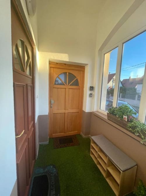 Entrée lumineuse avec porte en bois, fenêtres sur Illkirch-Graffenstaden, banquettes et plantes décoratives