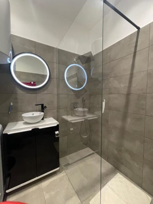 Salle de bain moderne à Illkirch-Graffenstaden avec douche vitrée, miroirs néon, vasque blanche et carrelage neutre